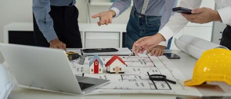 Collaboration and Construction Planning. Team members discussing architectural plans while reviewing building blueprints. photo
