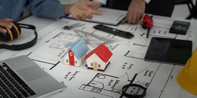 Architecture and Planning. Collaborators discussing building designs and ideas over architectural plans. photo