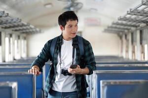 Exploration and Adventure. A traveler checks his phone for directions while exploring an empty train carriage. photo