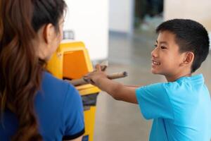 Engaging Youth in Recycling. A boy and a woman enthusiastically participate in waste sorting activities. photo