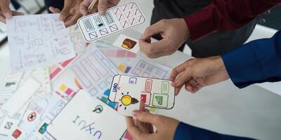 Creative Collaboration and UX UI Design. A team working together to refine wireframes for a mobile application. photo