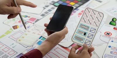 UX Design and Collaboration. Team members reviewing mobile app wireframes on a creative workspace. photo