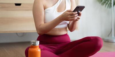 Hydration and Self-Care. A woman checking her phone after a yoga session, highlighting the importance of hydration and wellness. photo