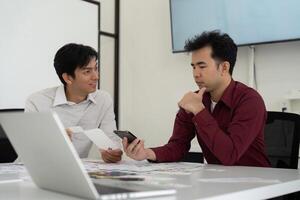 Collaboration and User Experience. Two designers discuss a mobile interface while analyzing design elements. photo