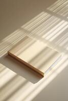 Blank white book with subtle shadows on background, offering a clean photo