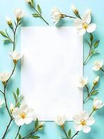 A blank white square card is framed by delicate white flowers with yellow centers against a soft blue background photo