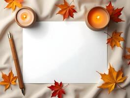 Blank paper with autumn leaves,and a candle on a soft fabric background photo