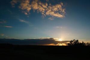 Dramatic sunset with clouds streaking the sky, warm colors photo