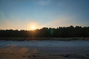 View of the dunes on the island of Usedom with forest, from the Baltic Sea at sunset. photo