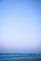 Moon in the sky in front of the beach on the island of Usedom on the Baltic Sea photo