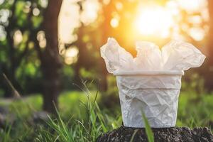 White Trash Can with Crumpled Paper in a Sunny Green Park photo