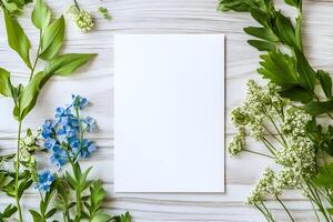Arrangement of colorful flowers and fresh foliage surrounding a blank invitation for mockup on a wooden surface creates a vibrant artistic workspace photo