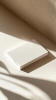 Minimalist white business card for mockup in soft sunlight on a beige surface with delicate shadows reflecting a tranquil atmosphere and simple design photo