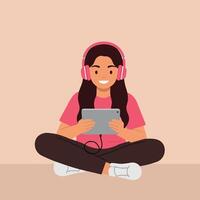 A cheerful girl sitting cross-legged on the floor using a tablet while wearing pink headphones in flat art vector