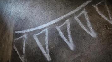 Chalk Drawn Triangular Flags on Rough Concrete Surface with Unique Patterns photo