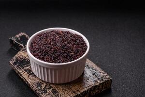 Red or brown raw rice in a white round ceramic bowl photo