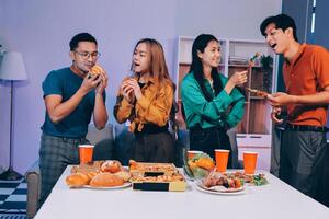 Four people eating pizza and drinking beer at a table photo