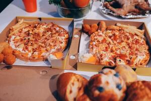 Two pizzas in boxes on a table photo