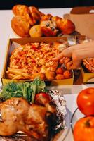 A person's hand reaching for a pizza photo