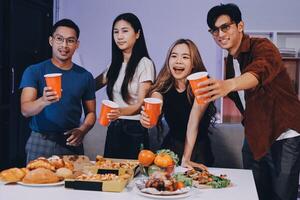 Four friends toasting with drinks at a table photo
