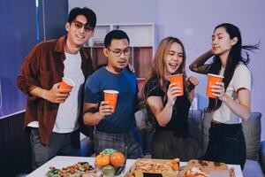 Four friends enjoying pizza and drinks photo