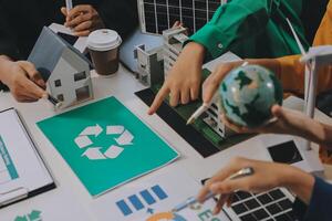 A group of people are working on a paper with recycling symbols photo