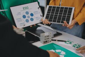 People holding up a solar panel and a paper with the words esg on it photo