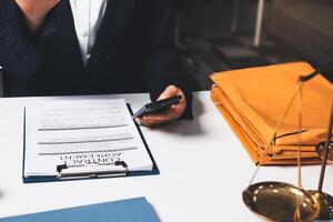 A woman in a suit is holding a phone and a paper with a document on it photo