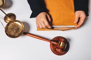 Businessman's hands holding a file and a gavel on a white table photo