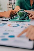 Business people working on a table with a globe photo
