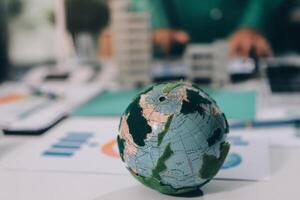 A small globe on a table with a business person in the background photo