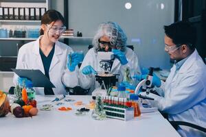 Three people in lab coats looking at a computer screen photo