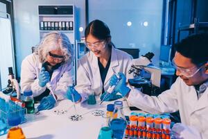 Three people in lab coats working on a project photo
