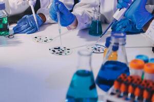 A group of people in lab coats and gloves working on a project photo
