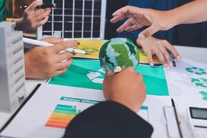 A group of people working on a paper with a globe on it photo