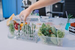 A person is holding a bottle of water over a table with vegetables photo