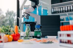 A microscope is on a table with a variety of vegetables photo