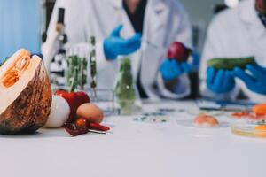 Two people in lab coats are working on a table with vegetables photo