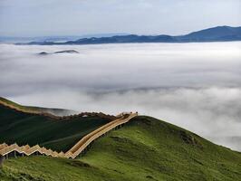 Endless Rolling Hills with a Trail Amidst a Sea of Clouds at Dawn photo