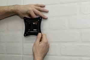 man tries on a wall mount bracket photo