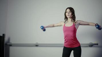 She works with a dumbbell in the gym video