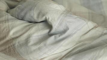 A closeup view of an inviting, cozy bed that showcases a soft, textured comforter and warm bedding pieces video