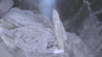 A detailed closeup view of textiles being thoroughly washed inside a washing machine, emphasizing the cleaning process video