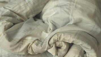 A closeup view of soft, rolled plaid bedding that offers a delightful sense of warmth and comfort for relaxation video