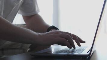 A person is actively using a laptop, typing away, showcasing modern technology in a bright and vibrant setting video