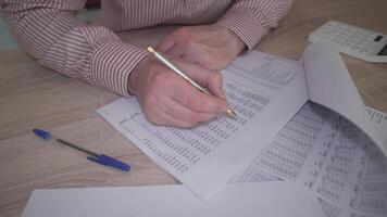 A dedicated professional engaged in analyzing financial data, utilizing paperwork and a calculator for accuracy video