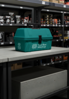 A teal tool box mockup sits on a concrete counter in a hardware store psd