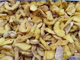 A pile of dried fruit with some pieces still attached. The fruit is yellow and has a brown tinge. photo