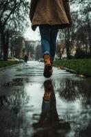 A person walking on a wet sidewalk photo