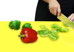 Slicing knife fresh bell peppers in red and green on green cutting board photo